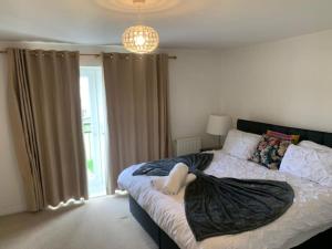 Un dormitorio con una cama con una manta. en Cozy Luxurious And Spacious 4 Bed Home, en West Thurrock