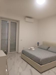 een witte slaapkamer met een bed en een raam bij Cuore di Napoli Centro in Napels