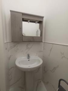 uma casa de banho branca com um lavatório e um espelho em Cuore di Napoli Centro em Nápoles