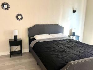 a bedroom with a large bed with a black headboard at Hollywood Gem 2 Bed Haven! in Los Angeles