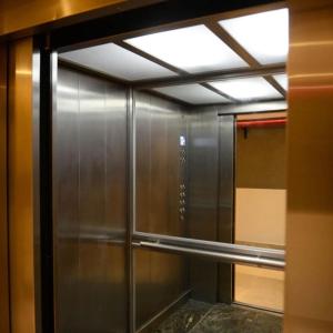 pasillo con ascensor de metal y ventana en Bravo Suites en el casco histórico de Salta, p/ 2. en Salta