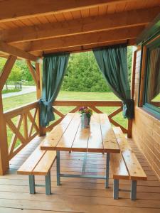 una mesa de picnic en el porche de una cabaña en Smrekowa Chatka w Milówce en Milówka