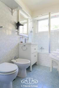 een witte badkamer met een toilet en een wastafel bij Scent of the Sea Apartment - L'Opera Group in La Spezia