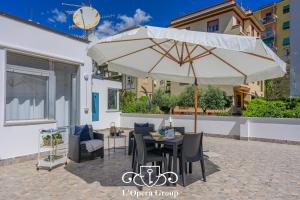 een patio met een tafel en een parasol bij Scent of the Sea Apartment - L'Opera Group in La Spezia
