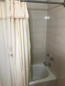 a bathroom with a tub and a shower curtain at Bahía x día 1 in Bahía Blanca