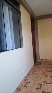 um quarto vazio com uma grande janela e piso em azulejo em Disfruta la Selva Peruana Pto.M em Puerto Maldonado