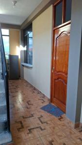 a hallway with a wooden door and a wooden floor at Disfruta la Selva Peruana Pto.M in Puerto Maldonado