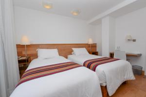 Postel nebo postele na pokoji v ubytování Hotel Plaza de Armas Cusco