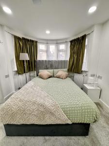 una camera da letto con un grande letto e un piumone verde di Urban Oasis In Harrow 2 Bed Home a Pinner