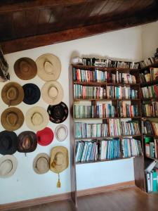 a room with hats on the wall and book shelves at The White house in Ollantaytambo