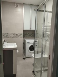 ein Badezimmer mit Waschmaschine und Waschbecken in der Unterkunft Faro da Borneira in Cangas