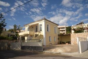 een wit huis met een balkon in een straat bij Blue Flag Award Winning Ormos Lo Beach: Home 1 in Vrontádos