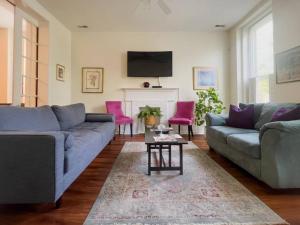 uma sala de estar com dois sofás e uma mesa em Mon Fournissuer 4bd Home with backyard em Louisville