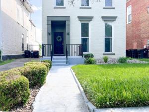una casa bianca con una porta blu e erba verde di Mon Fournissuer 4bd Home with backyard a Louisville