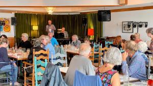 a group of people sitting at tables in a room at Hotel Wolfe Island in Marysville