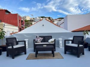Plaza de la fuente Granadilla de Abona Tenerife sur Only Adults con terraza privada في غراناديا دي أبونا: مجموعة من الكراسي وطاولة على الشرفة
