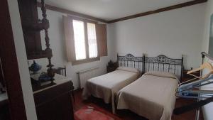 a bedroom with two beds and a window at Cristeta2 in Medina de Pomar