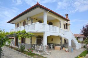 a large yellow house with a white balcony at Emmanuel's Summer House in Sozopoli