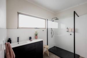 baño blanco con lavabo y ventana en Twelve 30 - easy airport access en Cambridge