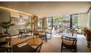 a restaurant with tables and chairs and large windows at Aminess Younique Narrivi Hotel in Crikvenica