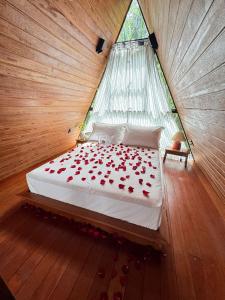 Un dormitorio con una cama con rosas rojas. en Cabana Ewaré en Presidente Figueiredo