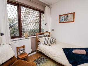 um pequeno quarto com uma cama e uma janela em Llys-Yr-Onnen em Carmarthen