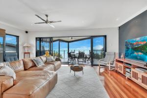 a living room with a couch and a flat screen tv at Marlin Lodge in Tangalooma