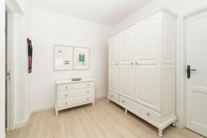 a white bedroom with a white wardrobe and a dresser at Casa El Drago 1 in Breña Baja