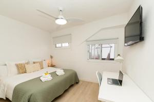 1 dormitorio con cama, mesa y TV en Casa El Drago 1, en Breña Baja