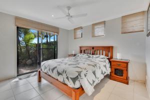 a bedroom with a bed and a large window at Marlin Lodge in Tangalooma