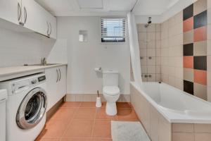 a bathroom with a toilet and a washing machine at Marlin Lodge in Tangalooma +21 photos