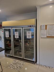 a display case in a bakery with trays of food at Hostel-Style GUESTHOUSE - for 18-40yrs in Caloundra