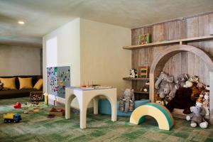 a childs room with a table and a play area with toys at Dinso Resort & Villas Phuket, Vignette Collection, an IHG Hotel in Patong Beach