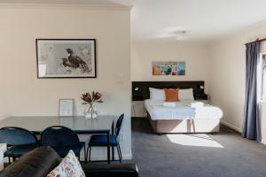 a bedroom with a bed and a table and a couch at Amber Court Motel Nelson in Nelson
