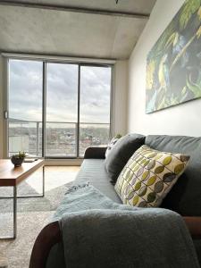 Apartment on Regent في ملبورن: غرفة معيشة مع أريكة زرقاء ونوافذ كبيرة