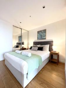 Apartment on Regent في ملبورن: غرفة نوم مع سرير أبيض كبير في غرفة