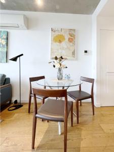 Apartment on Regent في ملبورن: غرفة طعام مع طاولة وكراسي زجاجية