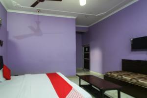 1 dormitorio con paredes moradas, 1 cama y 1 sofá en OYO Hotel Alfa, en Amb