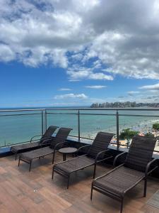 einen Balkon mit Stühlen und Strandblick in der Unterkunft Hotel Quatro Estações in Guarapari