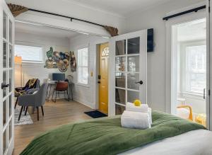 1 Schlafzimmer mit einem grünen Bett und einem Esszimmer in der Unterkunft Step into School Spirit at the Golden Dome Getaway in South Bend