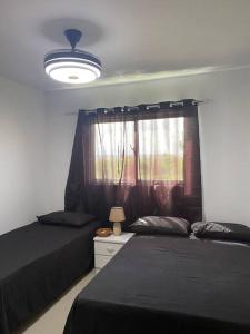 a bedroom with two beds and a lamp and a window at Luxury Penthouse Santo Domingo W in Santo Domingo +62 photos