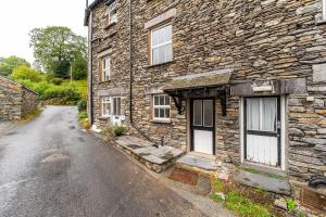 een oud stenen huis in een straat bij Dell Cottage in Ambleside