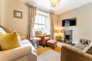 een woonkamer met een bank en een open haard bij Dell Cottage in Ambleside