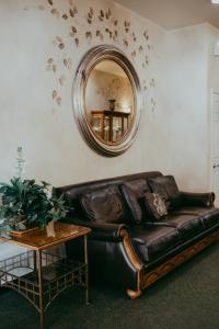 a leather couch in a living room with a mirror at Carson City Plaza Hotel in Carson City