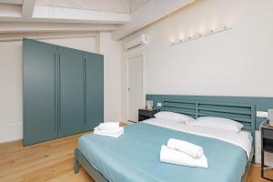 um quarto com uma cama azul com toalhas em CityCenter em Bérgamo