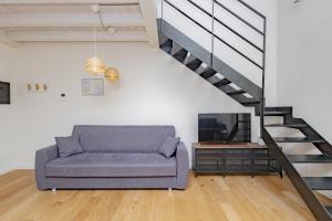 uma sala de estar com um sofá e uma televisão em CityCenter em Bérgamo