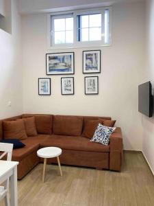 a living room with a brown couch and a table at KALLISTO's Apartment , 30m from the sea , Nea Plagia in Nea Plagia
