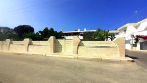 a stone retaining wall on the side of a street at The Lux Beach Apartments in Specchiolla