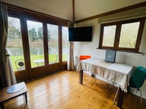a room with a table with a laptop on it at The Barn cottage with hot tub overlooking the lake in Ringmer