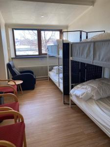 a dorm room with two bunk beds and a chair at Sjømannskirken Narvik in Narvik